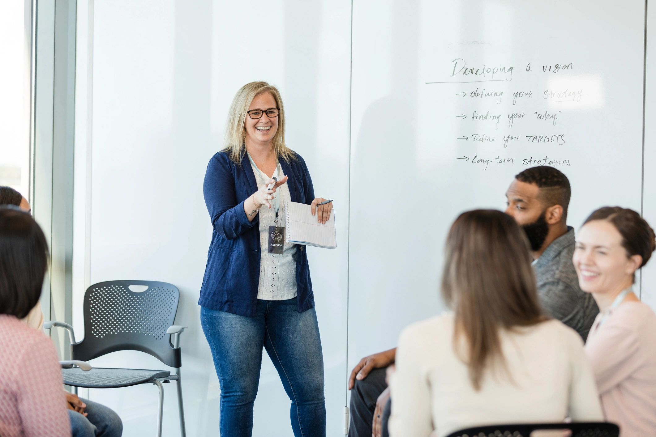 Consultant presenting a plan to a team at a whiteboard