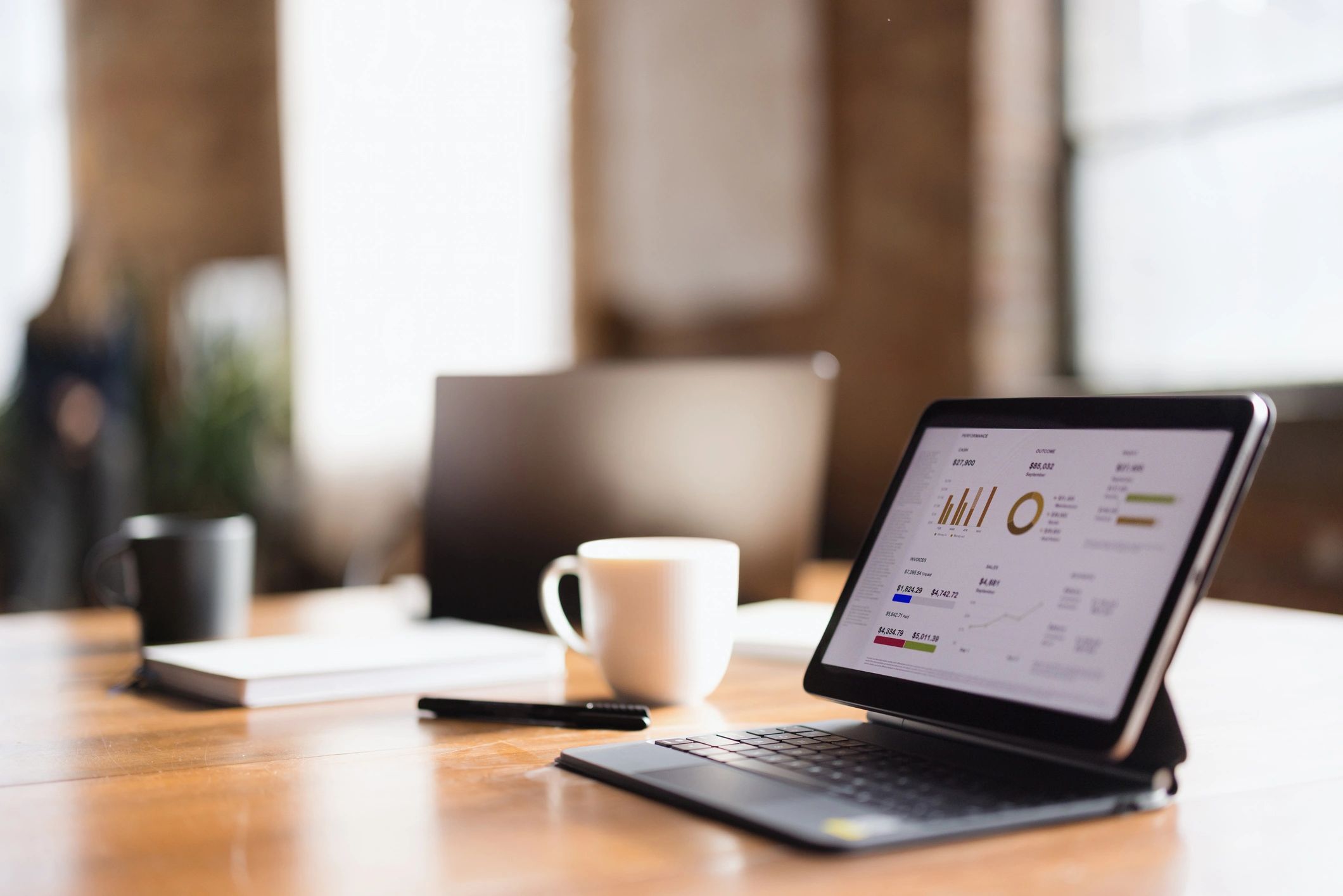 Financial modeling and analysis on a tablet at an office desk.